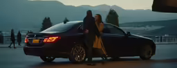 a man and woman leaning on the back of a black car