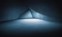 dark room with large concrete walls and white light