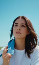 a woman wearing white holding a blue towel