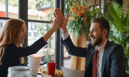 a man and woman clapping hands in a restaurant