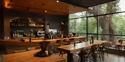 a large wooden dining table in front of a large glass window