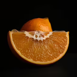 an orange slice on black background with a section cut off from the side