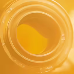 the bottom part of an orange glass bottle