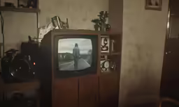 a tv is sitting in front of a small cabinet