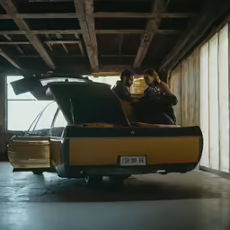 two people in the back of an old car