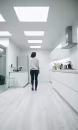 the back of a woman who is standing in a kitchen