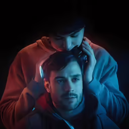 a young man is using his hair dryer while a young woman puts on her headphones