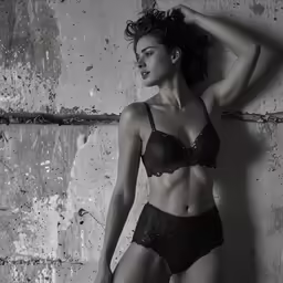 a sexy woman in a lingerie leaning against a wall