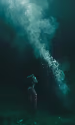 a woman standing under smoke as the sun sets
