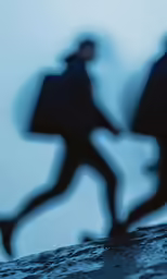 shadows of two people standing on top of a wave