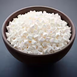a brown bowl filled with marshmallows on a table