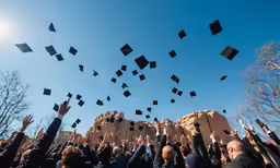 a group of people holding onto their graduation hats