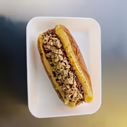 a white square plate holding a pastry with peanut butter