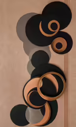 a pair of black and gold hoop earrings sitting on a beige sheet