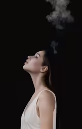 a woman blowing smoke on her face