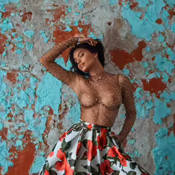 a woman wearing an open top and a flower skirt