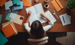 a woman is working on an open book