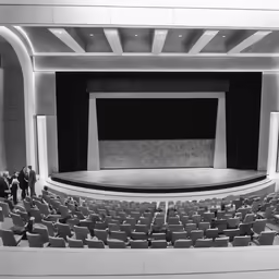 black and white photo of auditorium with people