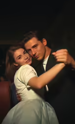 a man and woman dancing in the dark