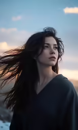 a woman is posing on the sidelines with her hair flying in the wind