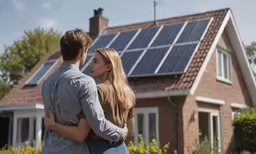 man and woman standing in front of solar panel roof