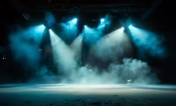 a set of lighting on a dark stage in smoke