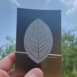 a leaf shaped card is held up in a hand