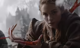 a woman holding an item with bloody hands