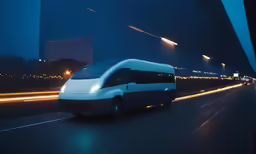 white van speeding down street at night with sky line in background