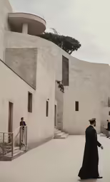two men walk by a building and another man walks past