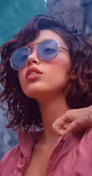 a model is dressed in pink shirt and gold sunglasses