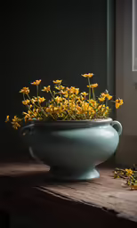 a blue vase holding yellow flowers on a table