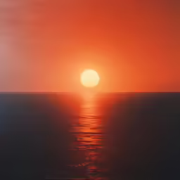 a sunset that is shining brightly over the ocean