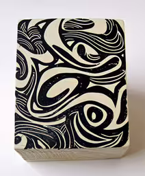 a black and white picture with artistic swirls in the middle,a black and white block with white designs