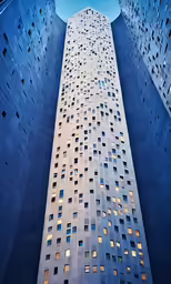the view up the side of a tall building in city at night