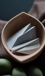 a bowl with some paper and some eggs on the table
