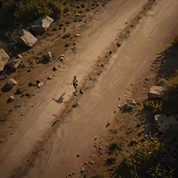 a person riding down a dirt road next to rocks and grass