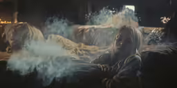 a person sitting on a couch covered in clouds of smoke