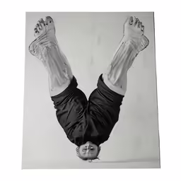 black and white photograph of man doing handstand