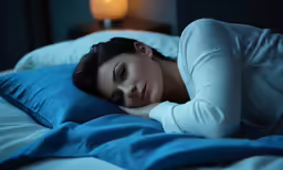 a woman laying down on top of a blue pillow