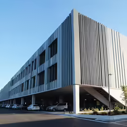 a big parking garage that has cars parked in front