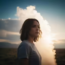 a woman in a field standing in the sun