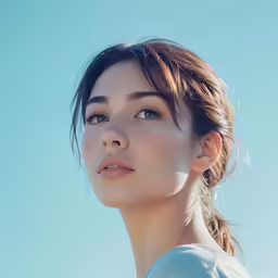 the woman is looking to her left with blue skies in the background