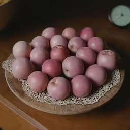 a plate topped with lots of little pink apples