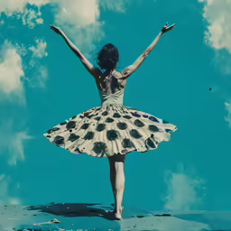 a woman dressed in a dress balancing her arms on a rock