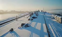 a train on a snowy track with mountains in the background