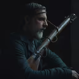 a man is sitting and holding an instrument
