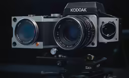 a camera with an open lens on a tripod