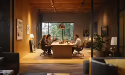 three people are sitting at a table talking