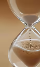 an hour - time sand timer on a brown surface